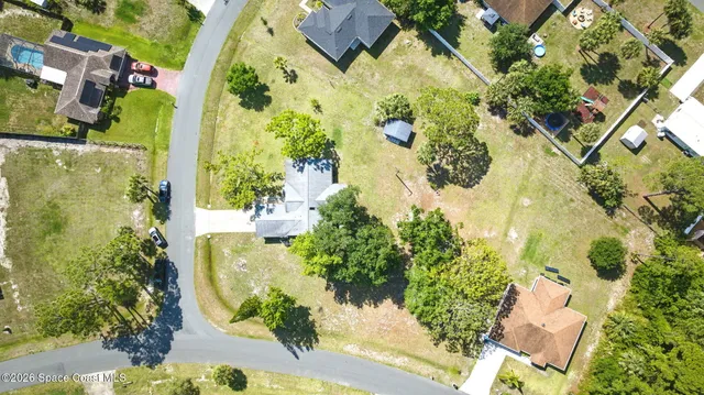 an aerial view of residential houses with outdoor space and swimming pool