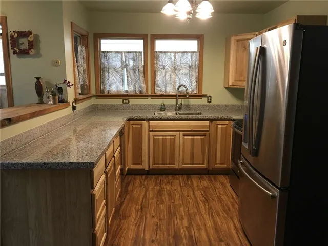 a kitchen with stainless steel appliances granite countertop a sink and wooden cabinets
