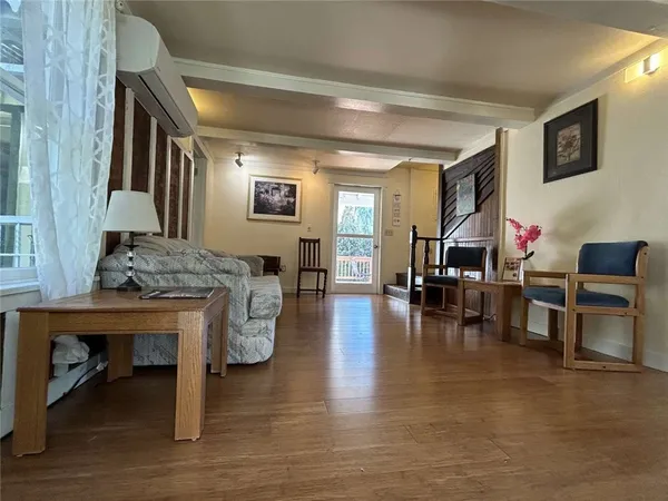a living room with furniture and a wooden floor