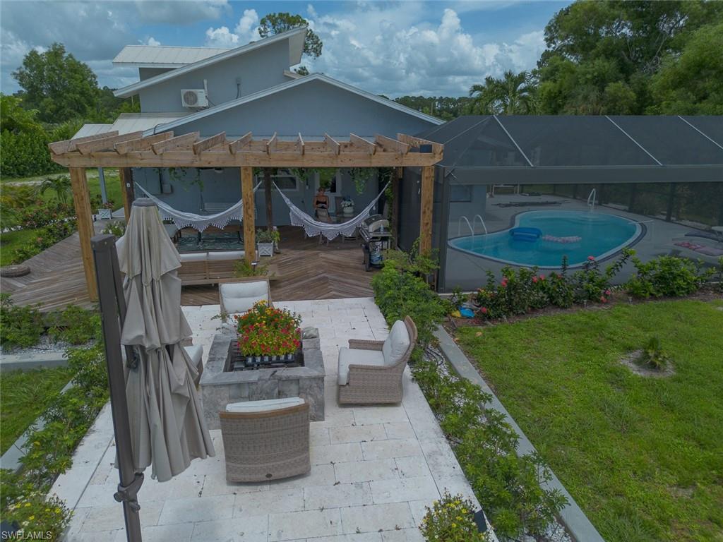 3220 63rd Street Southwest Naples, FL 34105 - Photo 32 of 36 View of patio / terrace with a pergola, an outdoor pool, glass enclosure, and a wooden deck