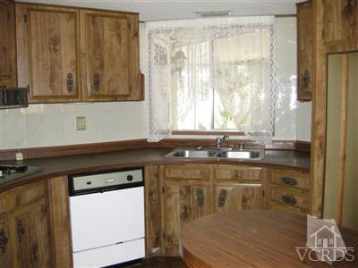 6480 Katherine Road, Unit 61 Simi Valley, CA 93063 - Photo 2 of 7 a kitchen with a sink a window and cabinets