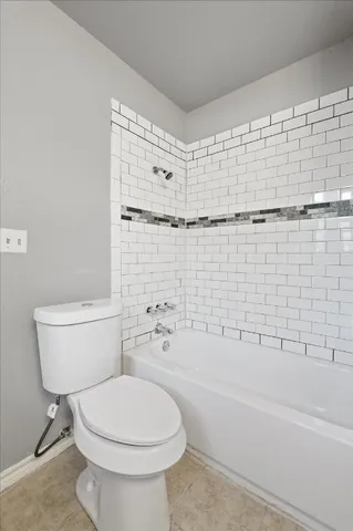 a bathroom with a toilet and a bath tub