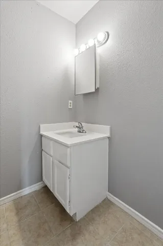 a utility room with a sink a vanity and a mirror