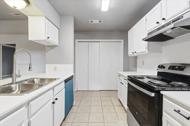 a kitchen with granite countertop a sink stove and cabinets