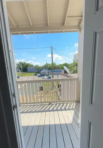 a view of a balcony with a floor to ceiling window with wooden floor