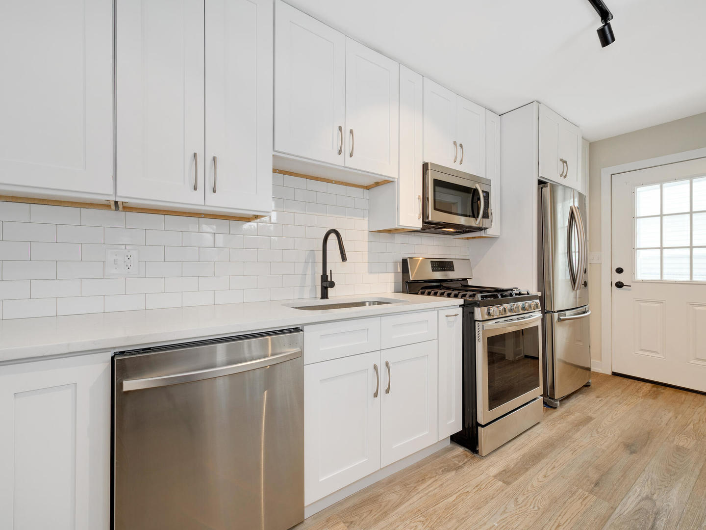 173 East Dennis Road Wheeling, IL 60090 - Photo 6 of 15 a kitchen with cabinets stainless steel appliances a sink and wooden floor