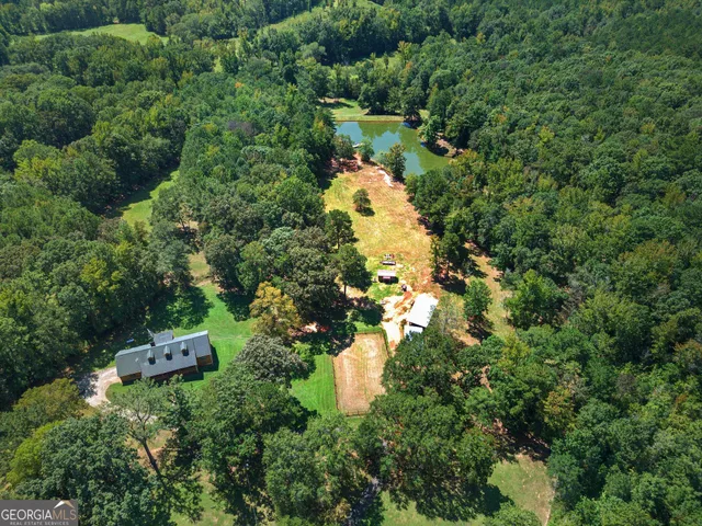 an aerial view of a house with a yard and large trees