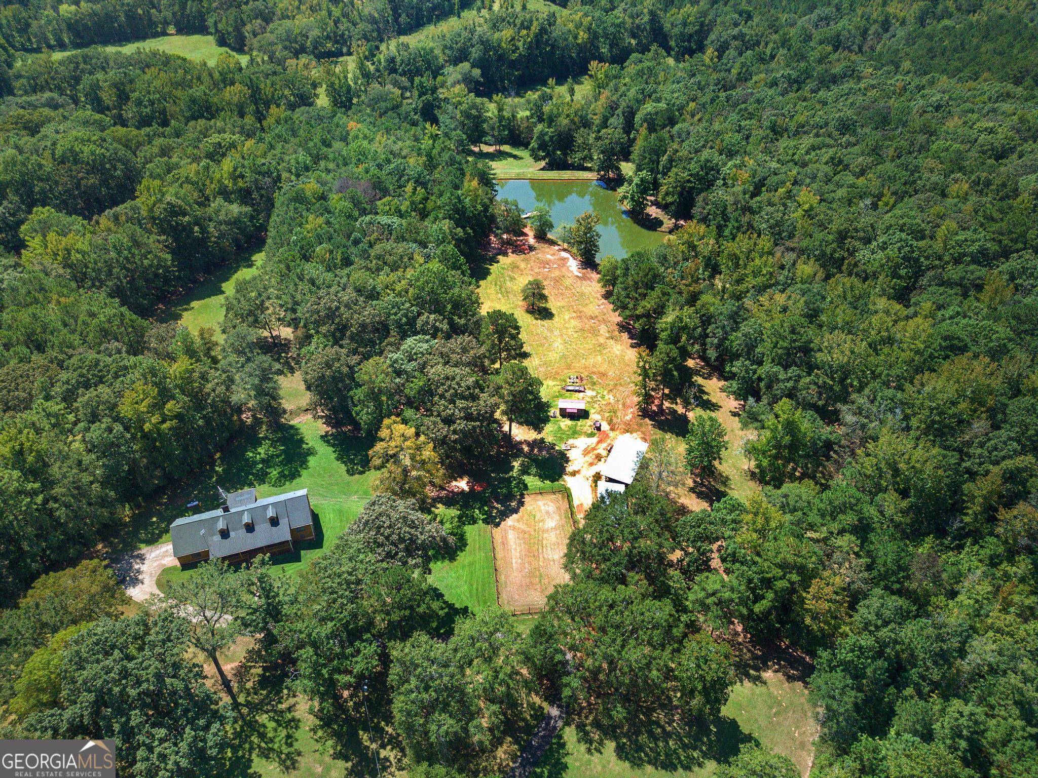 an aerial view of a house with a yard and large trees