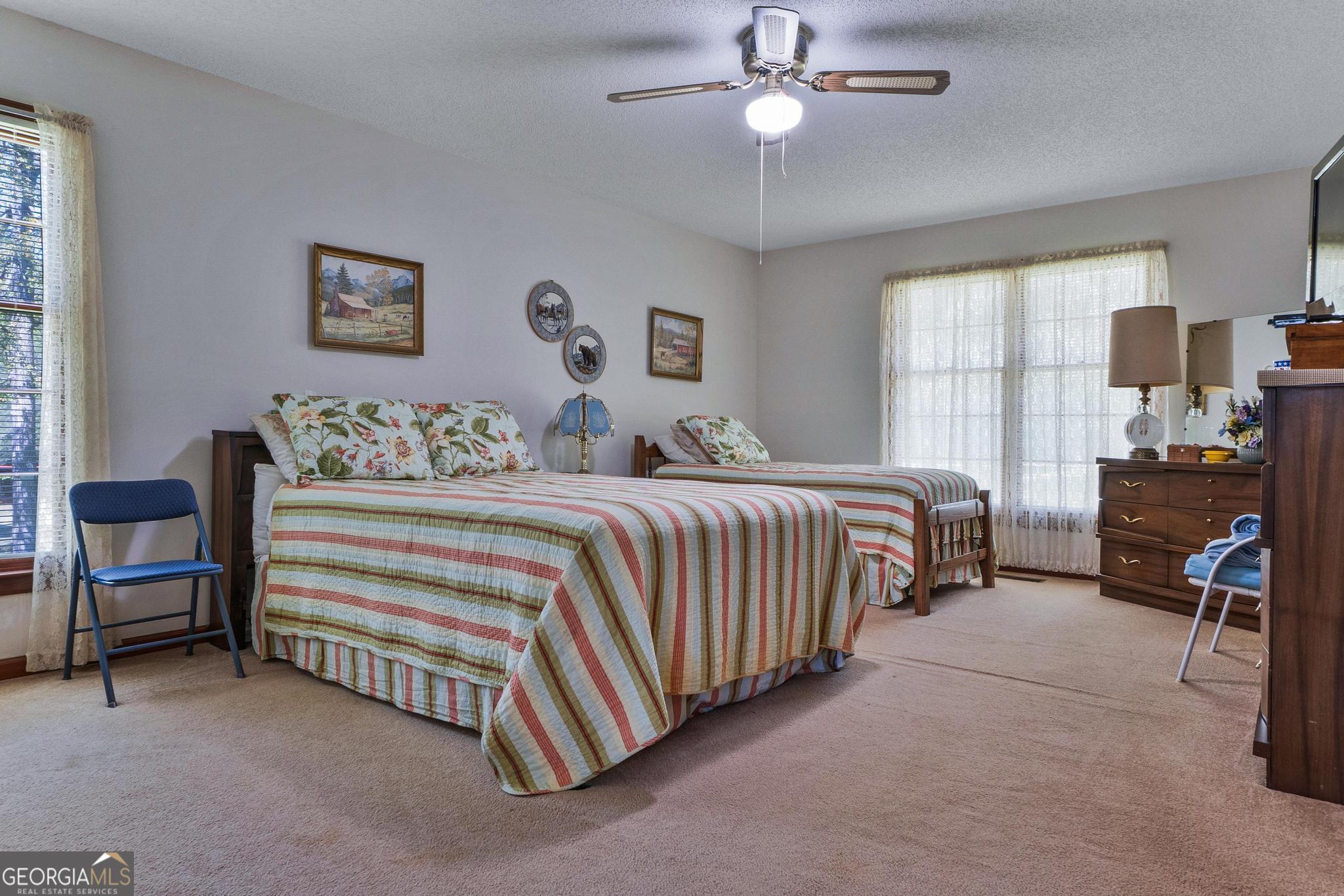 369 Abares Road Forsyth, GA 31029 - Photo 27 of 60 a bedroom with a bed and a chandelier