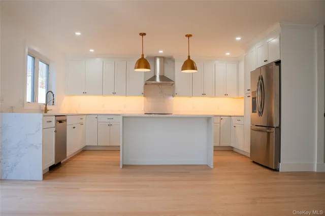 a large kitchen with stainless steel appliances a refrigerator and a stove top oven