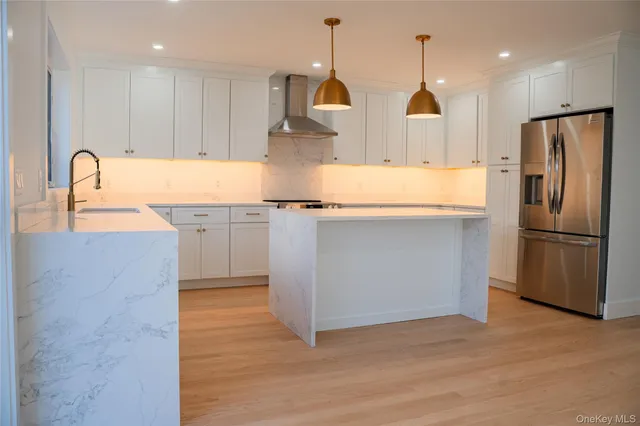 a kitchen with stainless steel appliances granite countertop a sink a stove and a refrigerator