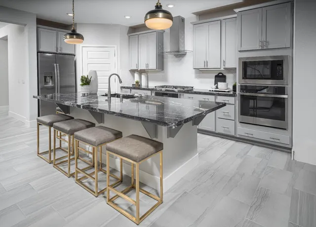 a kitchen with stainless steel appliances granite countertop a stove a sink and a refrigerator