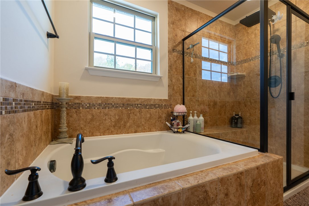 109 Smith Farm Way Easley, SC 29642 - Photo 18 of 37 Relax and unwind in this serene bathroom, featuring a deep soaking tub and a spacious shower.