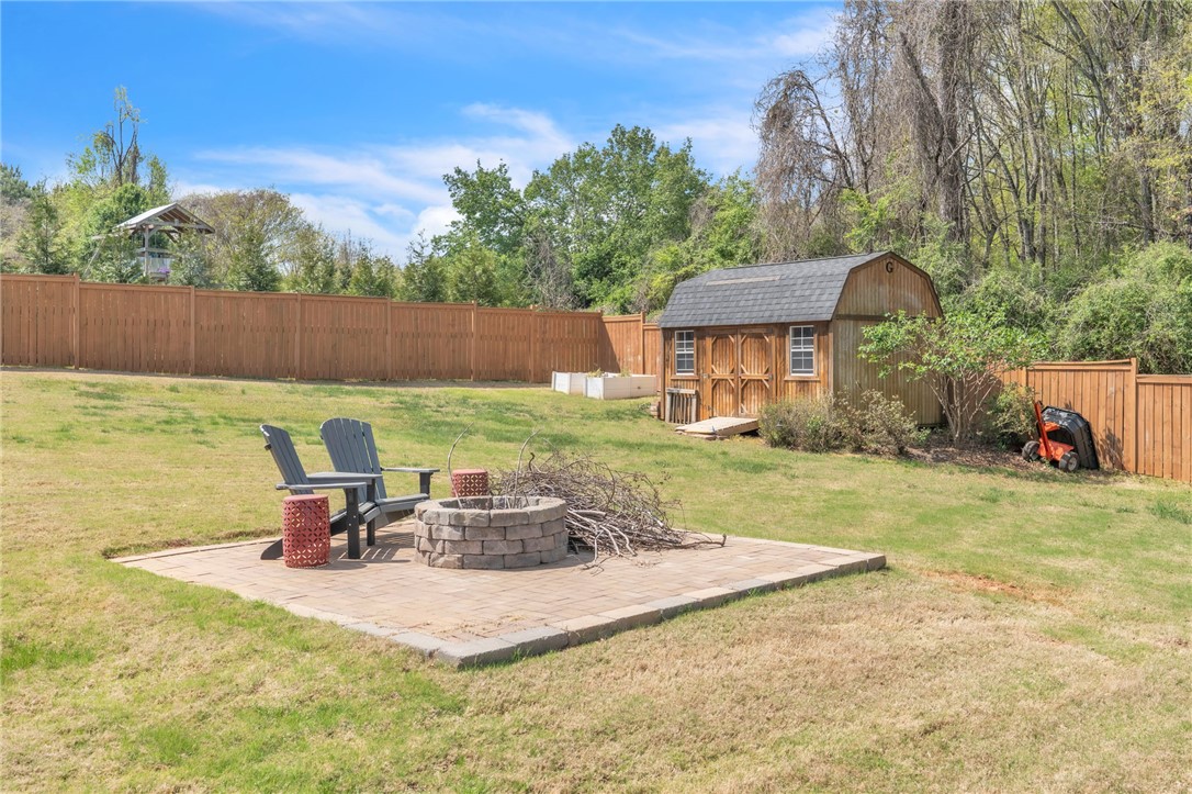 109 Smith Farm Way Easley, SC 29642 - Photo 32 of 37 This spacious yard offers a charming wooden shed and a cozy fire pit area.