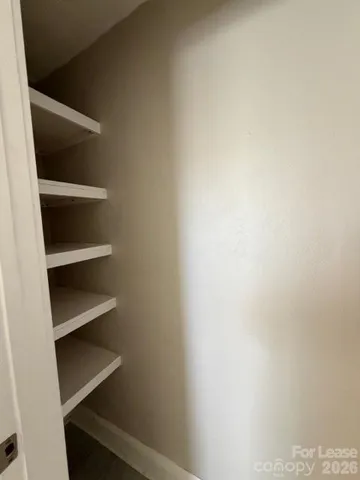 a view of walk in closet with empty racks