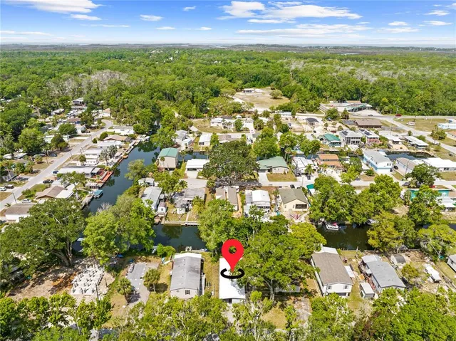 an aerial view of residential houses with outdoor space and trees all around