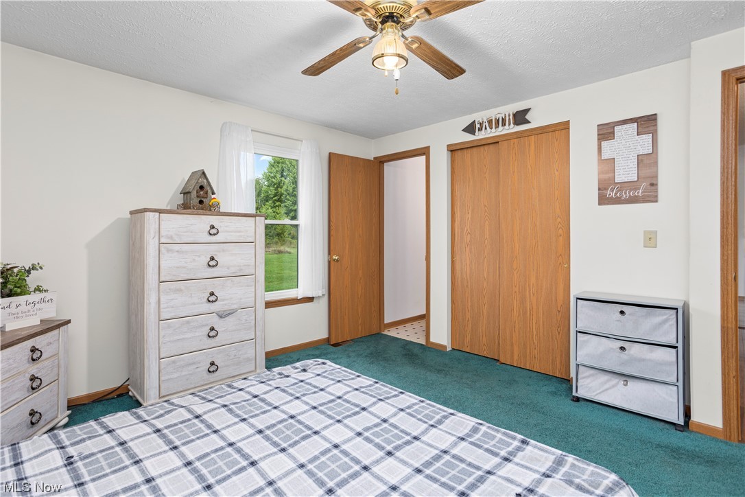 10965 Crawford Road Homerville, OH 44235 - Photo 19 of 35 Bedroom featuring a textured ceiling, light carpet, and ceiling fan