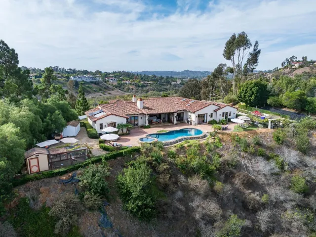 a view of a house with a big yard and large trees