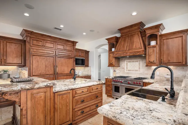 a kitchen with granite countertop a sink stove and cabinets
