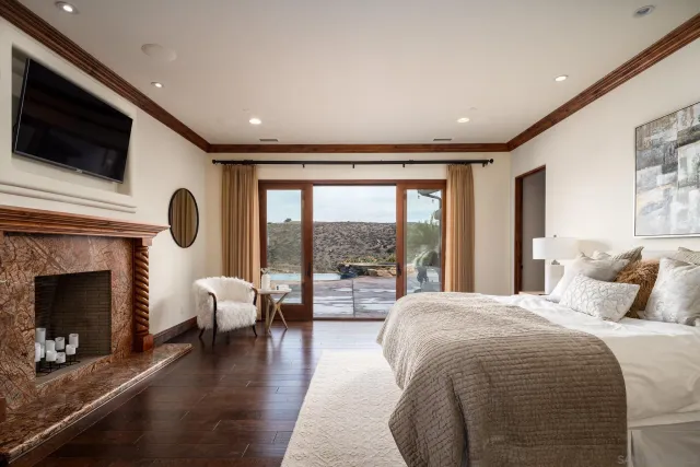 a bedroom with a large bed and a fireplace