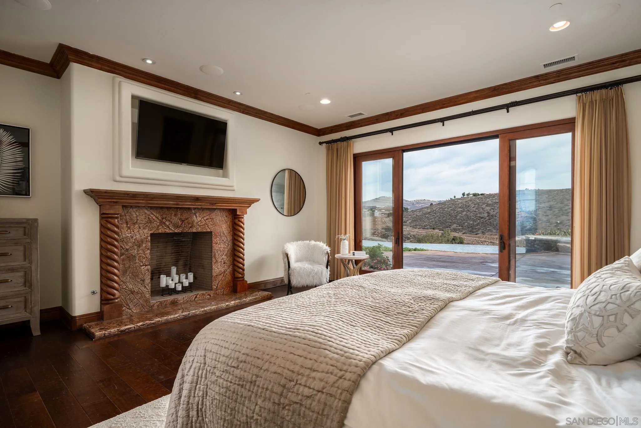 16531 Zumaque Street Rancho Santa Fe, CA 92067 - Photo 22 of 48 a bedroom with a large bed and a fireplace