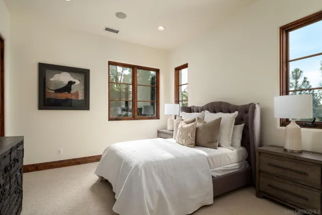 a bedroom with a large bed and a flat tv screen on dresser