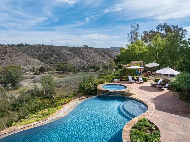 a view of a swimming pool with lounge chairs in patio