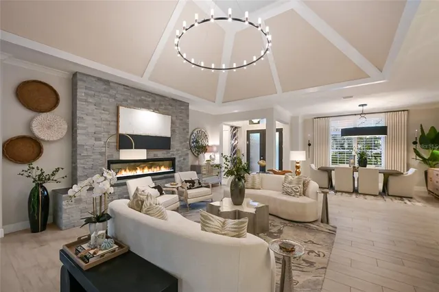 a living room with furniture a chandelier and a flat screen tv
