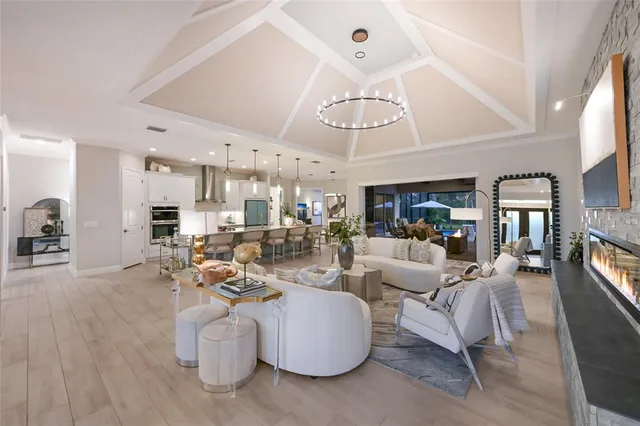 a living room with furniture a chandelier and a mirror