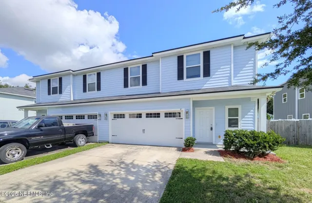 a front view of a house with a yard and garage