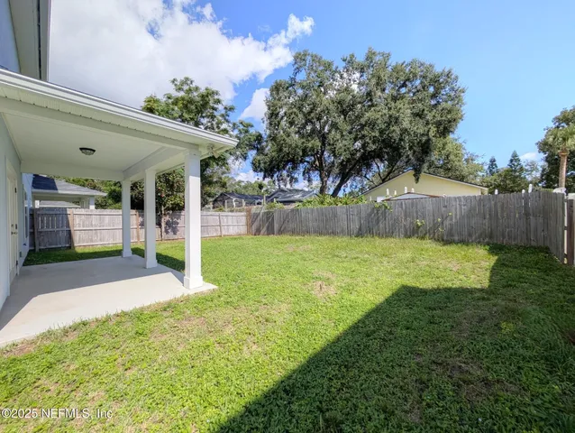 a view of a house with a big yard and large tree