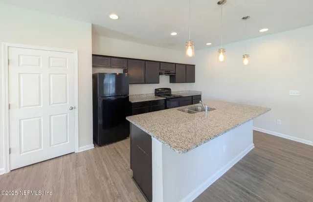 a kitchen with a sink refrigerator and cabinets
