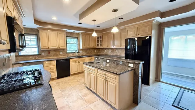 a kitchen with stainless steel appliances granite countertop a stove and a refrigerator