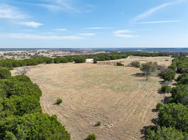 an aerial view of a house with a yard and ocean view