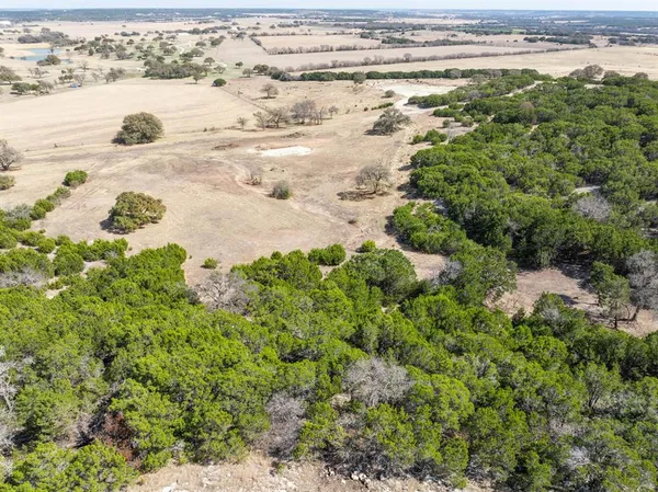 an aerial view of a houses with a yard and lake view