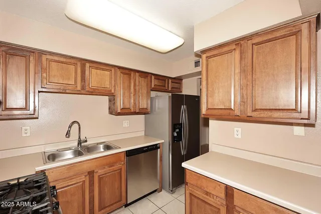 a kitchen with a refrigerator sink and cabinets