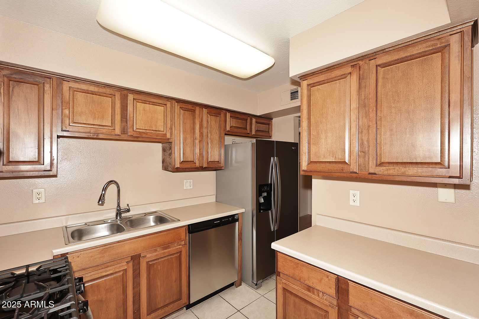 303 North Miller Road, Unit 1007 Scottsdale, AZ 85257 - Photo 14 of 28 a kitchen with a refrigerator sink and cabinets