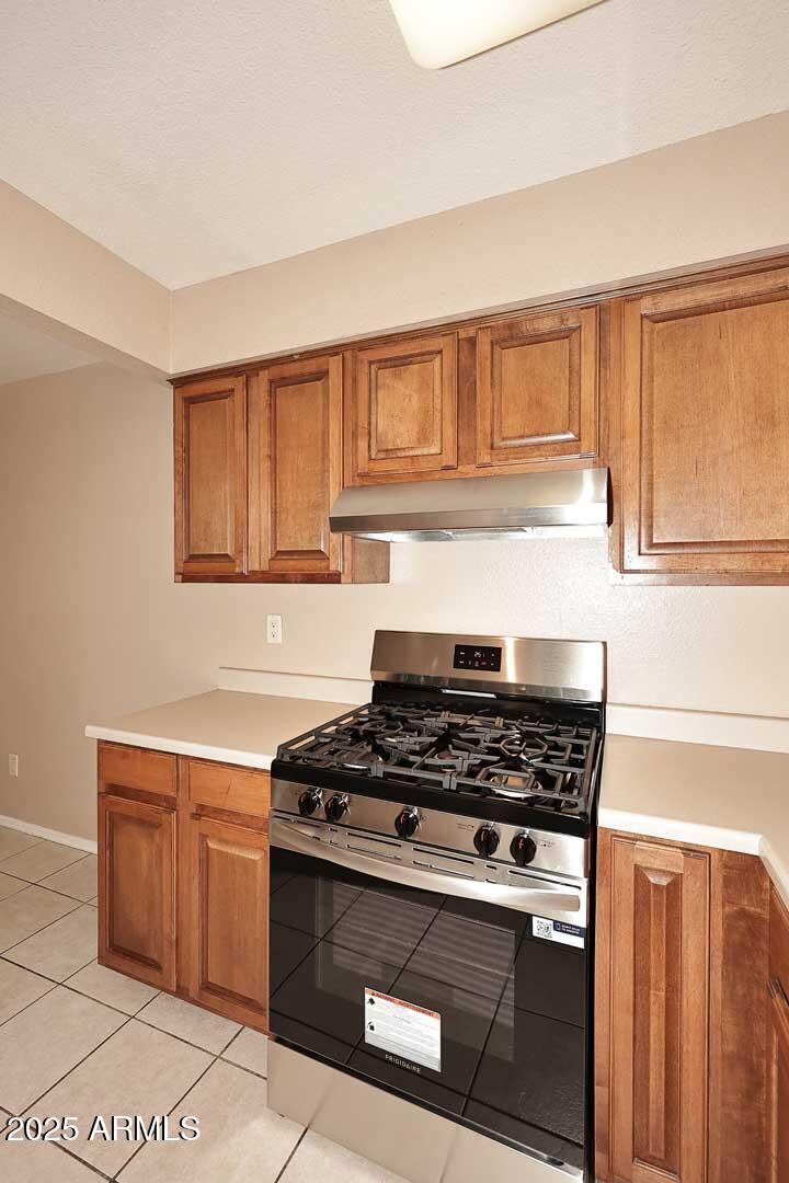 303 North Miller Road, Unit 1007 Scottsdale, AZ 85257 - Photo 15 of 28 a kitchen with granite countertop a stove top oven sink and cabinets