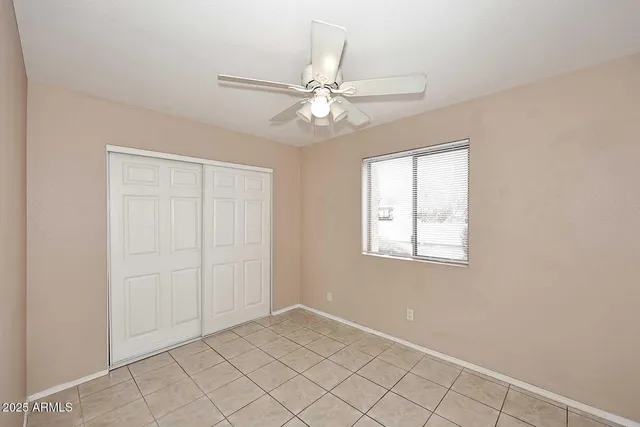 an empty room with fan and windows