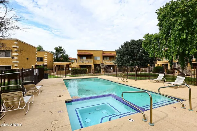 a view of a backyard with swimming pool and furniture