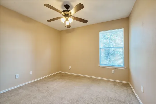 an empty room with closet and a chandelier fan