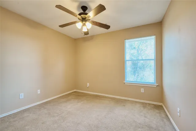 an empty room with closet and a chandelier fan