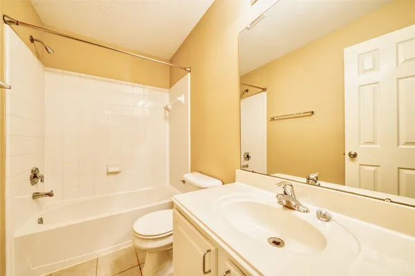 a view of a hallway with wooden floor and a bathroom