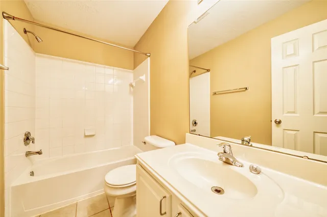 a view of a hallway with wooden floor and a bathroom