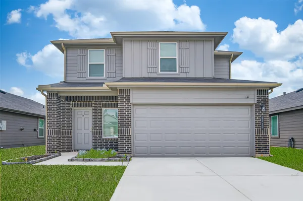 a front view of a house with a garden and garage