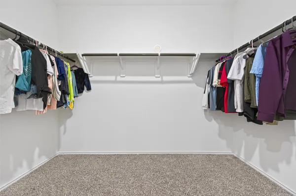 a view of walk in closet with clothes and shoes