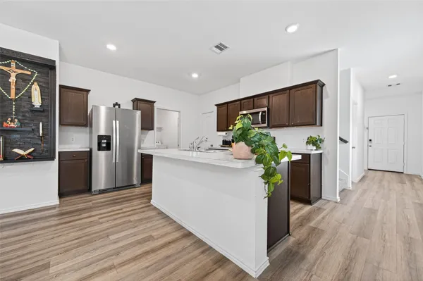a kitchen with stainless steel appliances a refrigerator sink and microwave