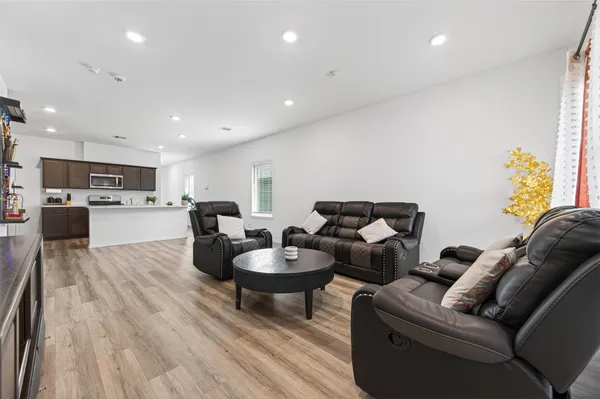 a living room with furniture and kitchen view