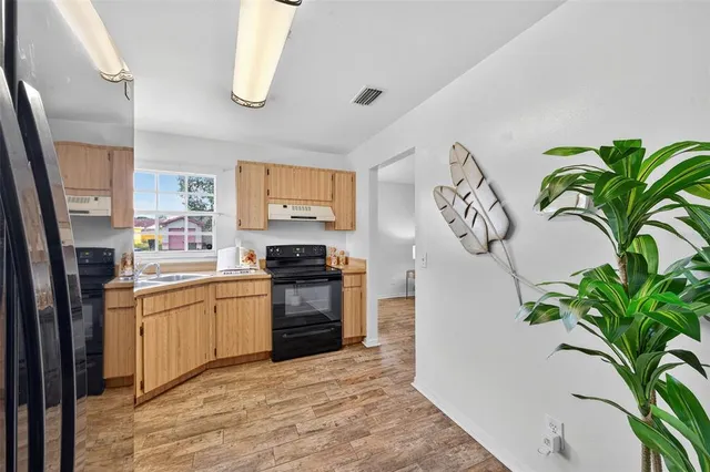 a kitchen with stainless steel appliances a sink a stove top oven a counter space and cabinets