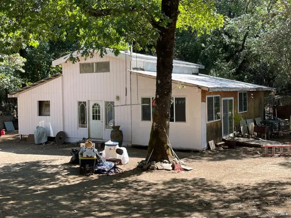 a view of a house with yard and sitting area